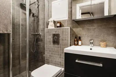 a bathroom with a shower and a sink and a toilet at Spacious 3 Bedroom Townhouse in Bergen