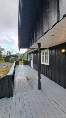 a wooden deck with a pole on the side of a building at Cozy Cottage in Rauland Vierli in Torvetjørn
