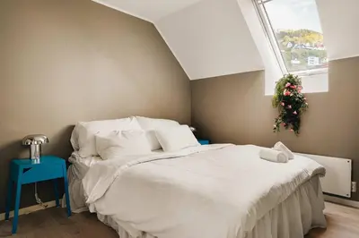 a bedroom with a white bed with a christmas wreath at DINBNB Apartments l 100m to Bryggen l Pet Friendly l Sleeps 4 l Smart-TV in Bergen