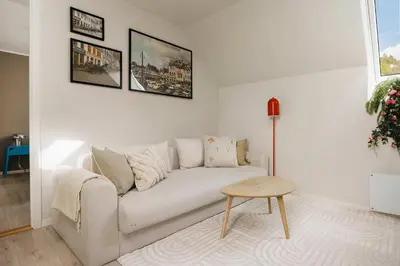 a white living room with a couch and a table at DINBNB Apartments l 100m to Bryggen l Pet Friendly l Sleeps 4 l Smart-TV in Bergen