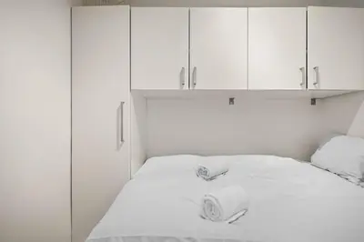 a white bed with two rolls of toilet paper on it at Bergen Beds Apartment I Right Behind Bryggen! in Bergen