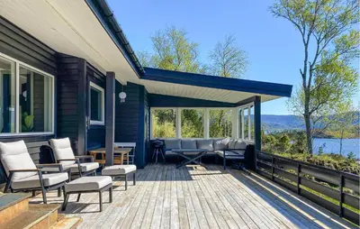 a house with a deck with chairs and tables at Knausen in Ørsta