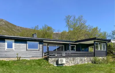 a house with a large porch on a green field at Knausen in Ørsta