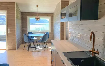 a kitchen and dining room with a table and chairs at Knausen in Ørsta