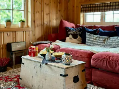 a living room with a red couch and a table at Family-Friendly Mountain Cabin At Haglebu in Haglebu