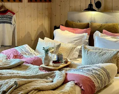 a pile of pillows sitting on top of a bed at Family-Friendly Mountain Cabin At Haglebu in Haglebu