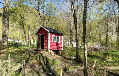 a small red house in the middle of a forest at Awesome Home In Ørsta in Ørsta