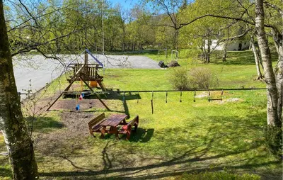 a park with a playground with a bench and a swing at 2 Bedroom Gorgeous Home In Ørsta in Ørsta