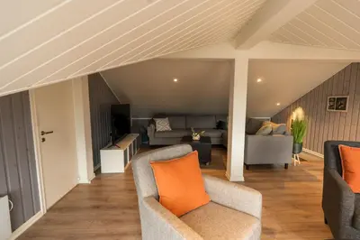 an attic living room with two chairs and a couch at Mountain View Lodge in Stranda