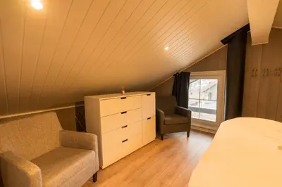 a bedroom with a bed and a chair and a dresser at Mountain View Lodge in Stranda