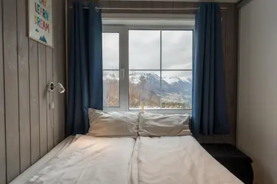 a bed in a room with a large window at Mountain View Lodge in Stranda