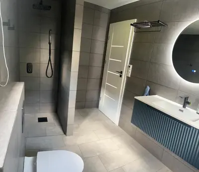 a bathroom with a shower and a toilet and a sink at Husslåttene apartments 2 in Skei