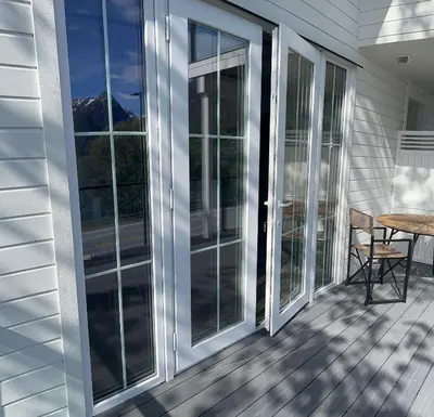 a screened porch with glass doors and a table at Husslåttene apartments 2 in Skei