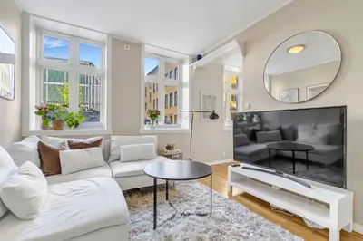 a living room with a white couch and a mirror at Central Charm in Bergen
