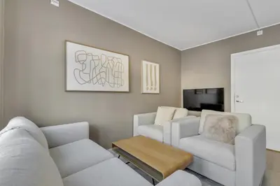 a living room with a couch and two chairs at Bryggen Gateway Homes in Bergen