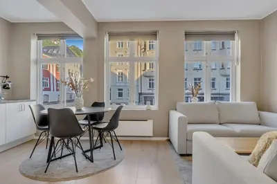 a living room with a table and chairs and a couch at Bryggen Gateway Homes in Bergen