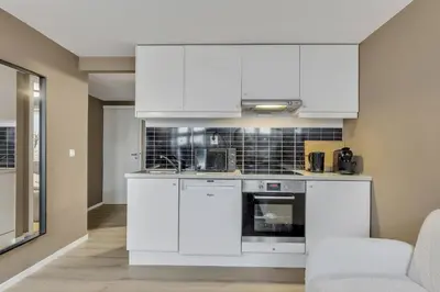 a kitchen with white cabinets and a stove at Bryggen Gateway Homes in Bergen