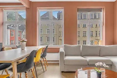 a living room with a table and chairs and a couch at Bryggen Gateway Homes in Bergen