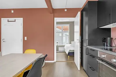 a kitchen with a table and some chairs at Bryggen Gateway Homes in Bergen