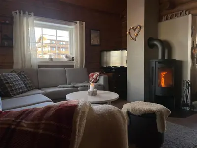 a living room with a couch and a wood stove at Log Cabin With Mountain View in Beitostøl