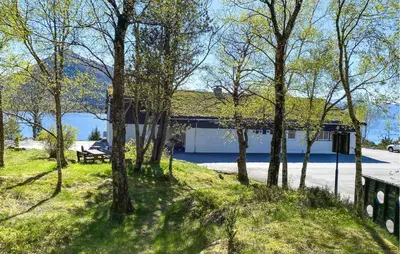 a park with a building with a bench and trees at Amazing Home In Ørsta With Wifi in Ørsta