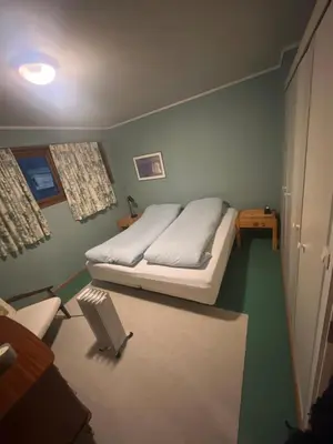 a bedroom with a bed in the corner of a room at 4 bedroom room House in Beautiful Strandebarm in Kvam