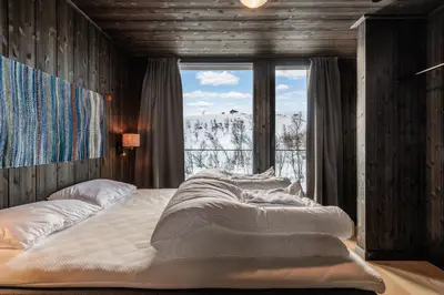 a large bed in a room with a large window at Kikut Alpin Lodge 1301 in Hol