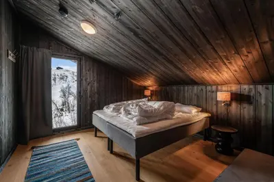 a bedroom with a bed in a wooden room at Kikut Alpin Lodge 1301 in Hol