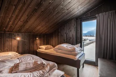 two beds in a room with a window at Kikut Alpin Lodge 1301 in Hol