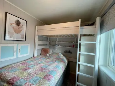 a small bedroom with a bunk bed and a ladder at Strandhus i idylliske omgivelser in Batnfjordsøra