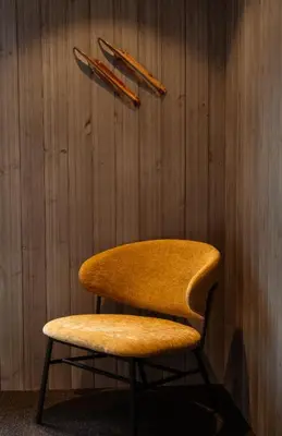 a wooden wall with a chair and two sticks at Sov Lodge in Vågåmo