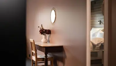 a room with a desk and a bed and a mirror at Sov Lodge in Vågåmo