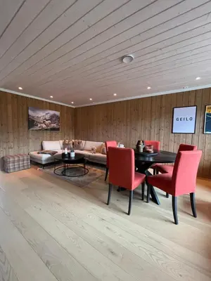 a living room with a table and chairs and a couch at Beautiful City Cottage at Geilotunet in Hol