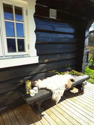 a bench on a wooden deck with a window at Mountain villa with amazing view of Hardangervidda! in Nørdstebø