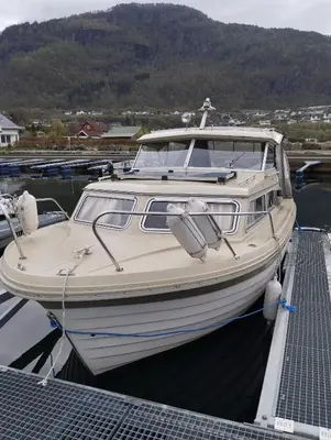 a boat is docked at a dock in the water at Flamingo in Vikedal