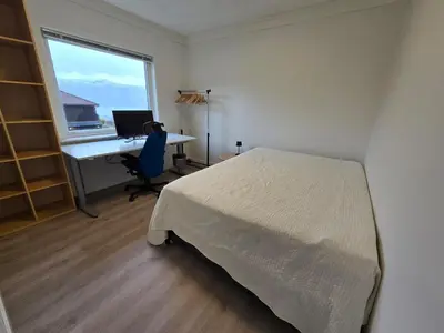 a bedroom with a bed and a desk with a computer at 6 Bedroom House in Ålesund