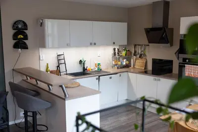 a kitchen with white cabinets and a counter top at Big apartment in central Aalesund in Ålesund