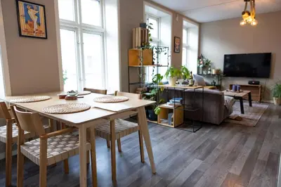a living room with a table and chairs and a tv at Big apartment in central Aalesund in Ålesund