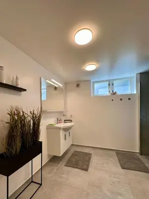 a kitchen with a sink and a counter in a room at Cozy basement apartment in Ålesund