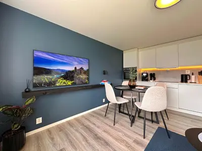 a kitchen with a table and chairs in a room at Cozy basement apartment in Ålesund