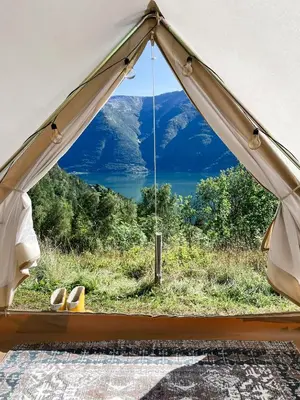 a tent with a view of a lake and mountains at Glamping Kalhagen in Vangsbygd