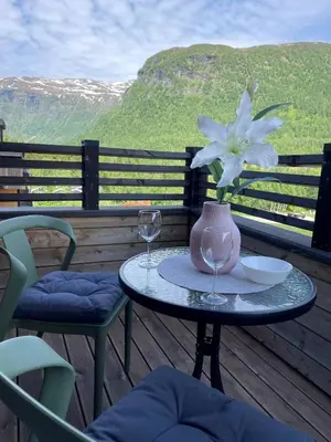 a table with two glasses and a vase with a flower at Helgatunlia - Leilighet 1 in Vossevangen