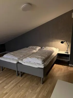 a bed in a bedroom with a wall at Helgatunlia - Leilighet 1 in Vossevangen