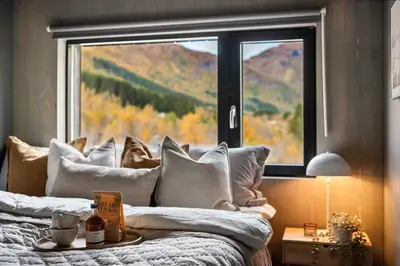 a bedroom with a bed with a large window at Helgatunlia - Leilighet 1 in Vossevangen
