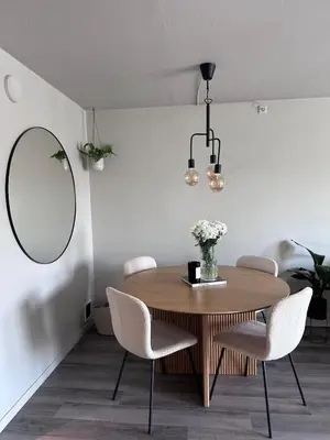a dining room with a table and chairs and a mirror at Sentral leilighet i Åsane in Sørebø