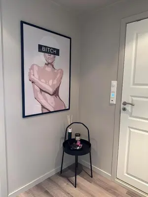 a black table with a picture of a woman on a wall at Sentral leilighet i Åsane in Sørebø