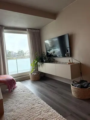 a living room with a tv and a large window at Sentral leilighet i Åsane in Sørebø
