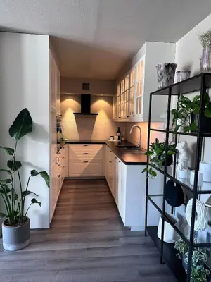 a kitchen with white cabinets and plants in it at Sentral leilighet i Åsane in Sørebø