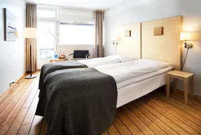 a hotel room with a large bed and a window at Dølaheimen in Lillehammer