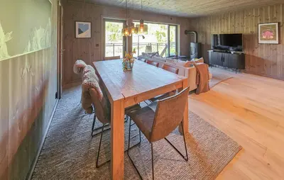 a dog sitting at a wooden table in a living room at Stunning Apartment In Hemsedal in Hemsedal